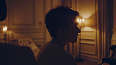 silhouette of a person playing piano in a luxurious room at night