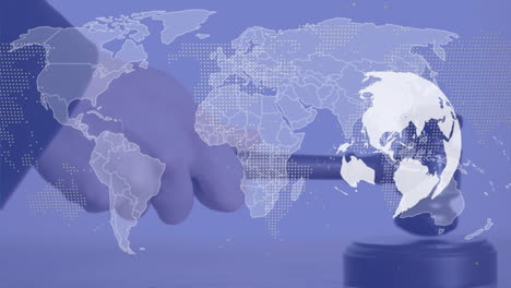 animation of world map and globe over hand using gavel