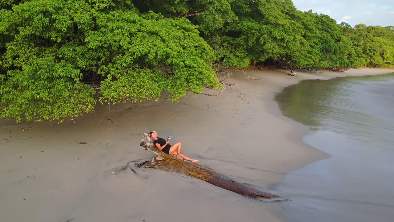 vista aérea de una mujer relajándose en una tranquila playa tropical en el parque natural, manuel antonio, costa rica