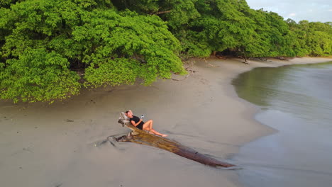 Vista-Aérea-De-Una-Mujer-Relajándose-En-Una-Tranquila-Playa-Tropical-En-El-Parque-Natural,-Manuel-Antonio,-Costa-Rica.