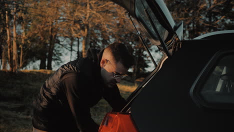 cheerful motivated good-looking caucasian businessman preparing a car trunk before a business journey