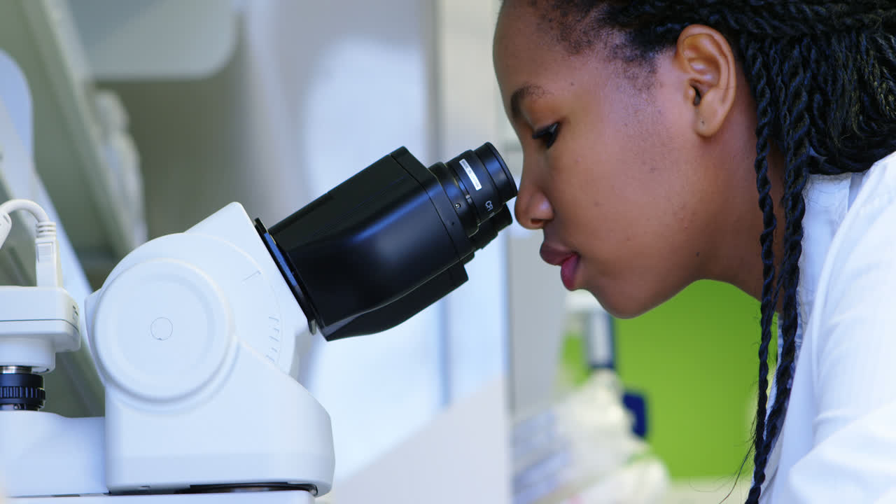 Scientist looking through microscope 4k