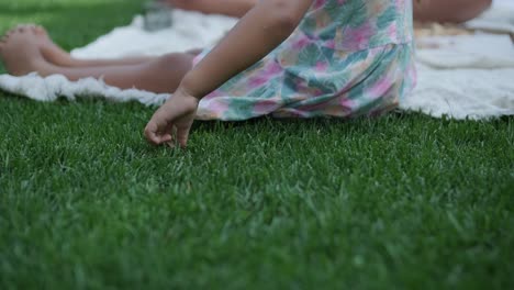 a mother and daughter enjoy a summer picnic outdoors on a grassy lawn, sharing pizza and spending quality time together on a sunny day. the family bonding scene reflects leisure and relaxation.