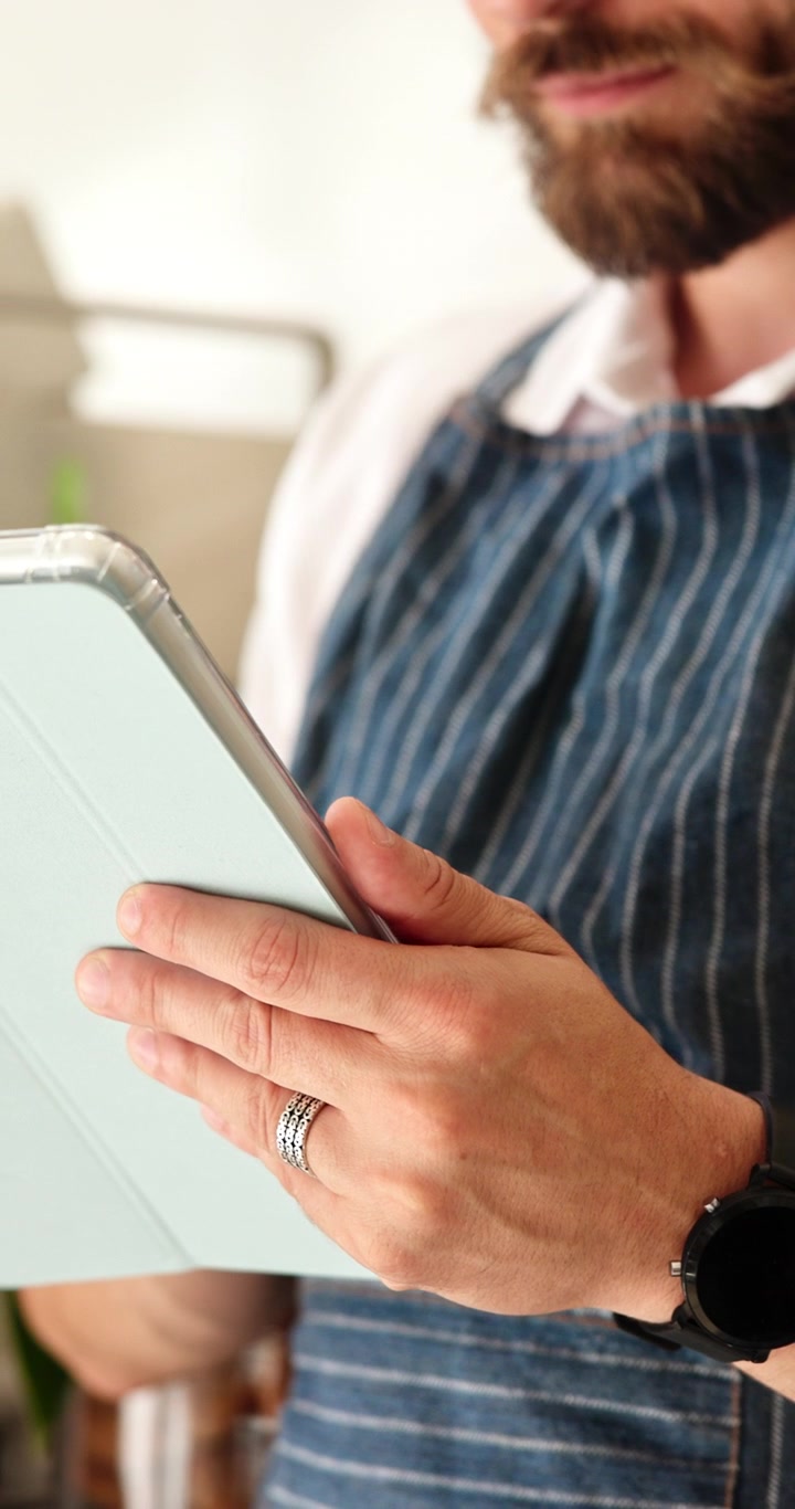 Bearded Man in Apron Using Digital Tablet