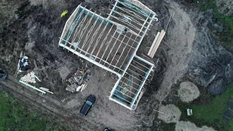 sitio de construcción de una nueva casa familiar en el campo en un día de otoño malhumorado, vista aérea de arriba hacia abajo