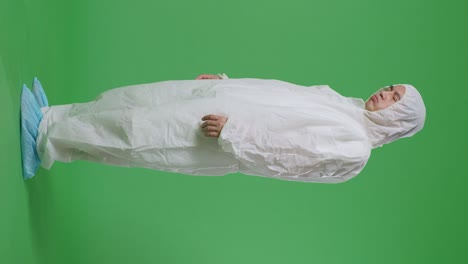 full body side view of asian male scientist having a headache while standing on green screen background