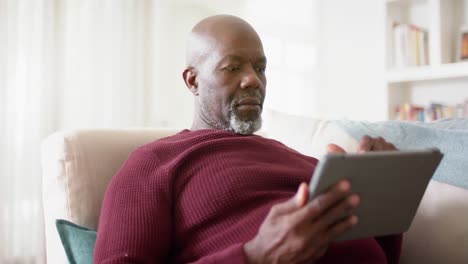 Afroamerikanischer-älterer-Mann,-Der-Zu-Hause-Ein-Tablet-Benutzt,-Zeitlupe