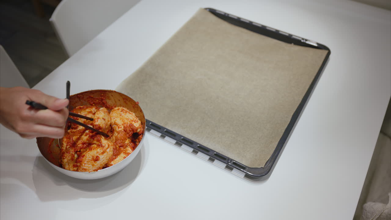 mujer luchando con palillos, cocinando en la cocina, dificultades para usar palillos, alas de pollo marinadas, cocinar en casa, preparación de comidas, consumo de carne, ingesta de proteínas, dieta baja en calorías