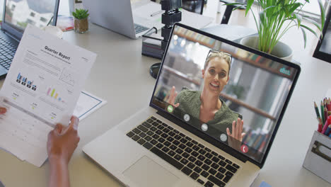 mujer de negocios afroamericana usando una computadora portátil para una videollamada con un colega de negocios caucásico
