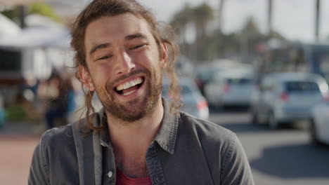 portrait of happy young man laughing enjoying carefree vacation lifestyle looking cheerful independent male on warm sunny urban beachfront