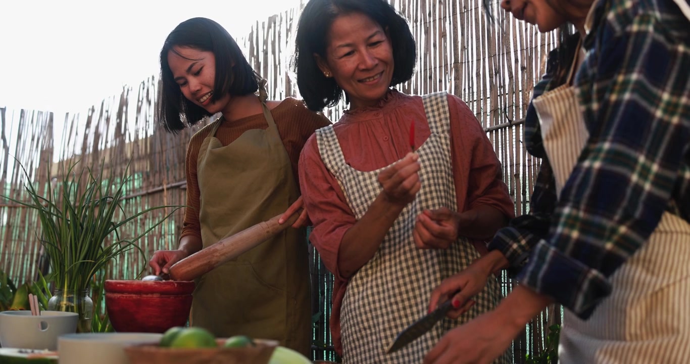 Donne asiatiche felici che preparano cibo tradizionale all'aperto