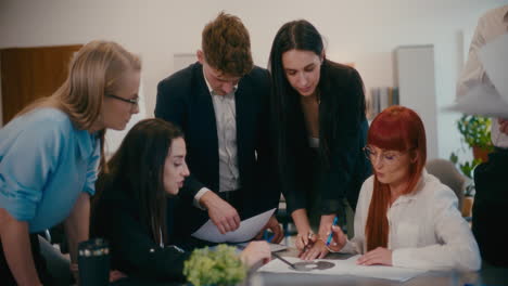 Businesswoman-discussing-with-employees-in-office.