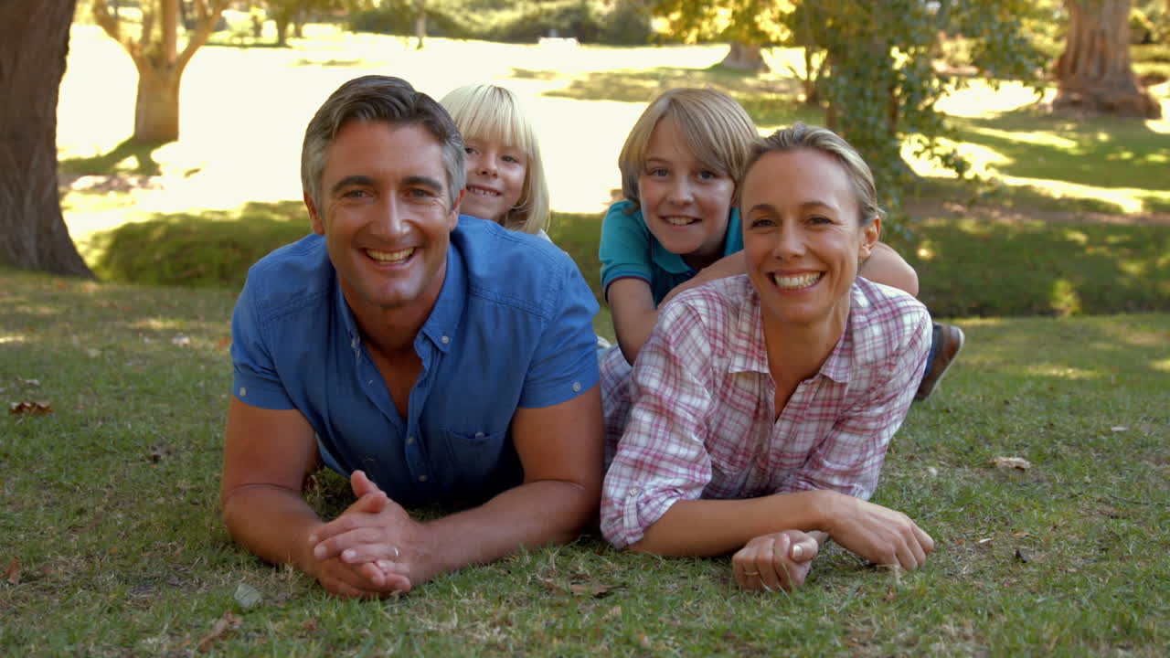 Happy family smiling at the camera in the park