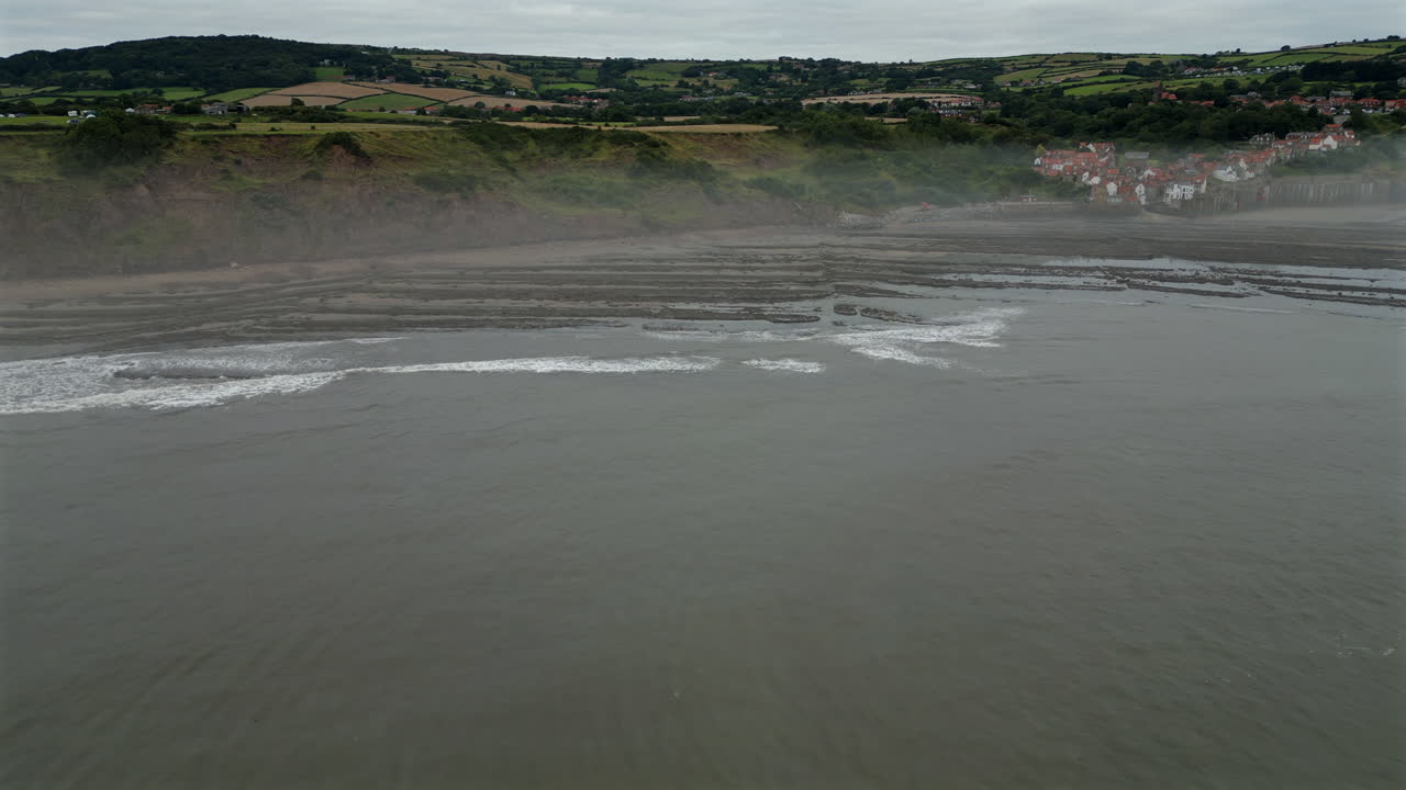 Establishing Aerial Drone Shot of Robin Hood's Bay Coastal Village on Misty Morning at Low Tide