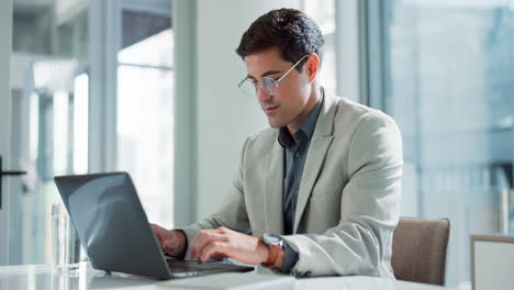 Hombre que trabaja en la computadora portátil en la oficina