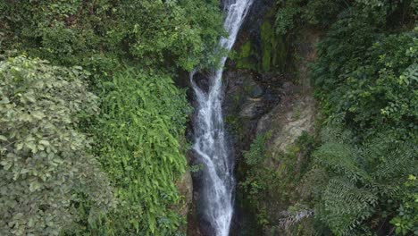 ascending drone shot waterfall hidden in tropical rain forest jungle