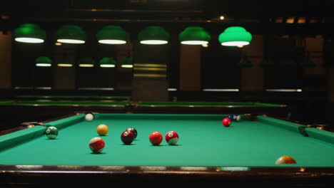 playing american billiard poule close-up. colorful balls on green billiards table .billiard balls with numbers on a pool table. billiards team sport.high quality 4k footage