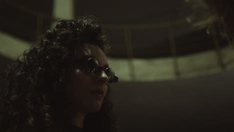 woman in sunglasses looking at friend at night