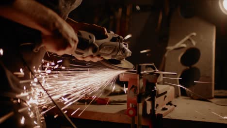 el hombre lija metal con un molinillo eléctrico que produce muchas chispas