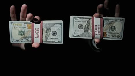 two stacks of 10000 american dollars bundles in male hands on black background