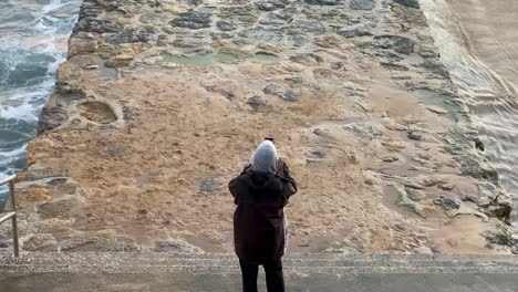 acercar a un joven haciendo algunas fotos de una enorme puesta de sol en la playa