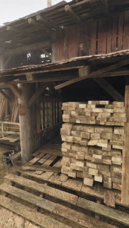 a rustic building with stacks of wooden planks