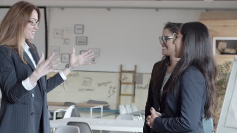 compañeros de trabajo dándose la mano y hablando en la oficina