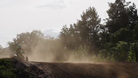 shot of quad bikers race in the jumping zone , hopping over the hill