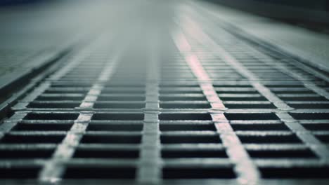 a close-up view of a metal grate surface, showcasing its pattern and texture under subtle lighting conditions, ideal for industrial or architectural themes