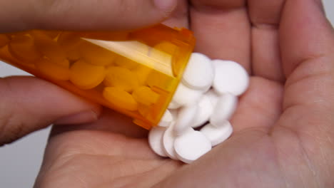 doctor pours out bottle full of pills onto their hand