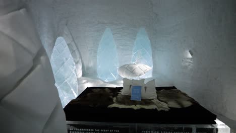 ice room with bed and ice sculptures in ice hotel in scandinavia, sweden