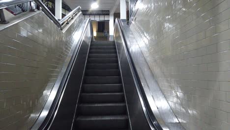 Escaleras-Automáticas-Metálicas-Plateadas-Primer-Plano-Del-Ascensor-En-Paredes-De-Azulejos-Antiguos-Subiendo