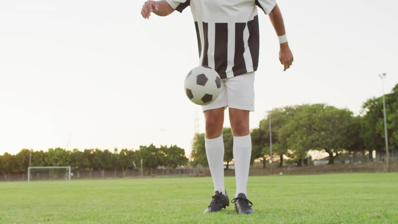 video de un jugador de fútbol biracial en el campo con la pelota