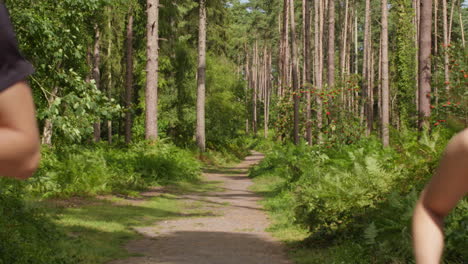 pareja adulta en medio del ejercicio haciendo ejercicio al aire libre corriendo a lo largo de la pista a través del bosque hacia la cámara con ropa deportiva 1