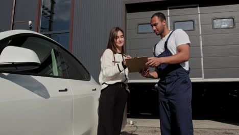 cliente discutiendo la reparación del coche con el mecánico