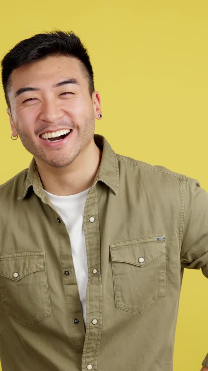 Laughing man in front of yellow background