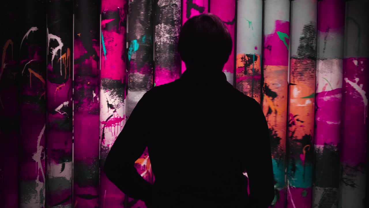 Persona che osserva un'installazione d'arte astratta