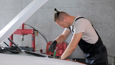 mecánico trabajando en un coche en un garaje