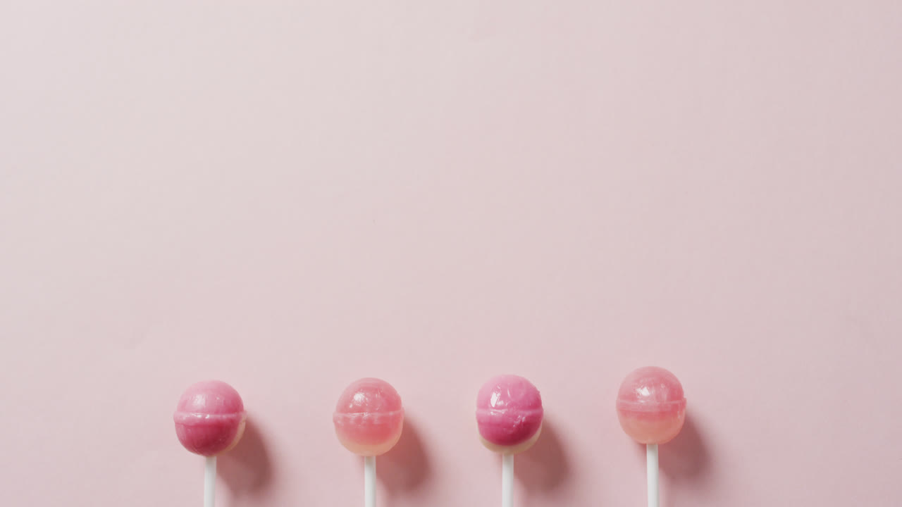 Video of pink lollipops on pink background