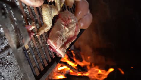 grilling meat using glowing embers, argentinian asado - vertical shot