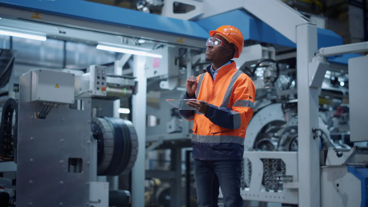 Supervisor holding transparent tablet moving virtual pieces at machinery plant