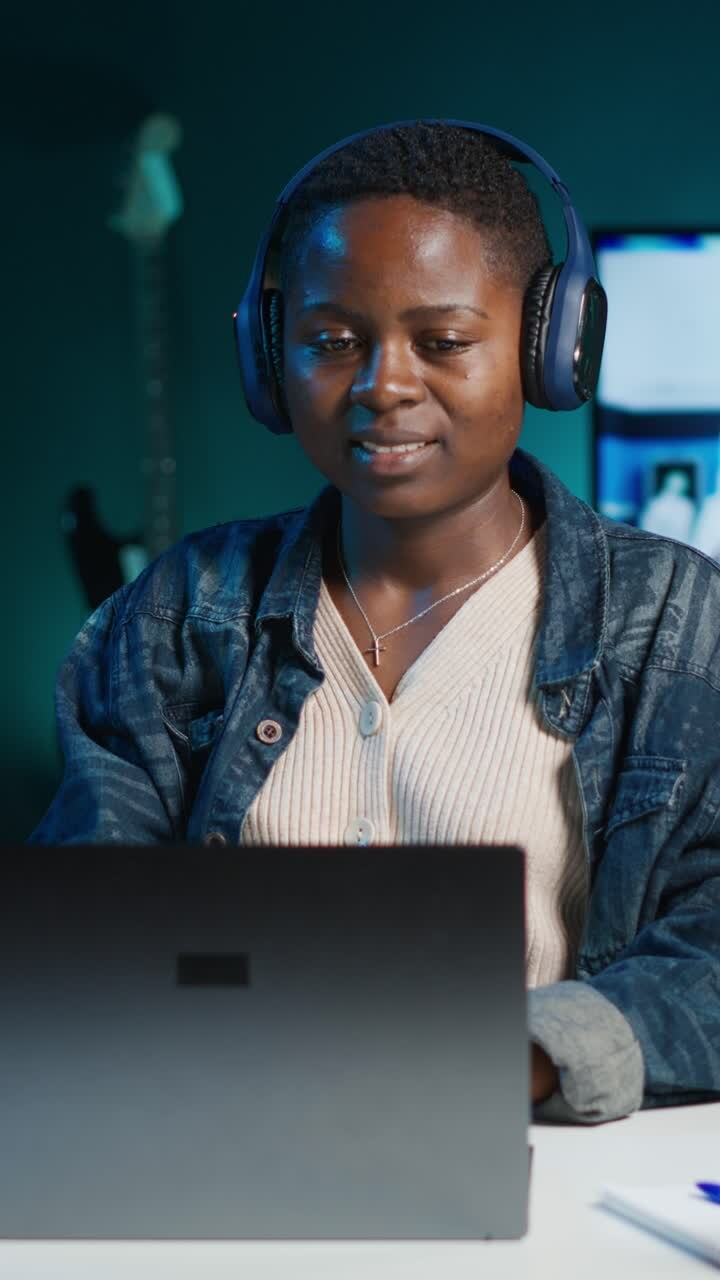 Video verticale. Donna che ascolta musica in ufficio/salotto mentre risponde alle e-mail