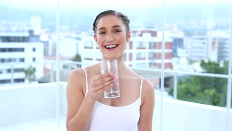 Cheerful-young-woman-drinking-water