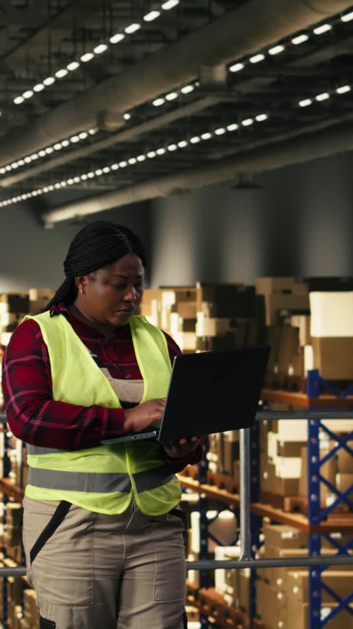 Video Verticale: Operaio di Magazzino Usa un Laptop per Ottimizzare la Logistica dell'E-commerce