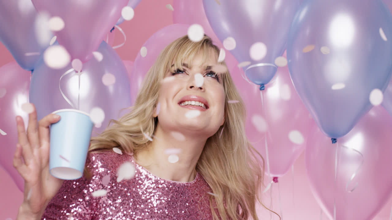 아름다운 젊은 여성이 춤을 추고 생일 파티를 축하하고 있습니다. 분홍색과 파란색의 풍선 배경 - 빨간 에픽 드래곤