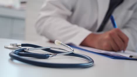 Handheld-view-of-stethoscope-and-working-doctor-in-the-background