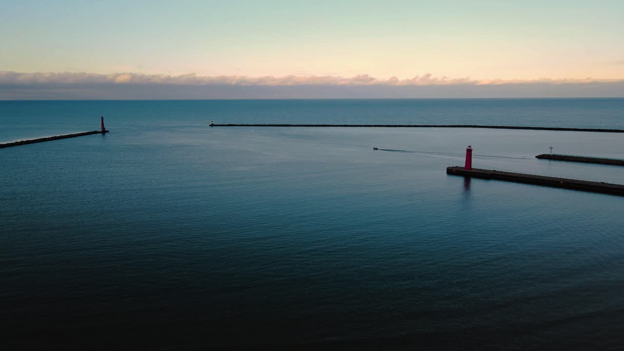 무인 항공기를 통해 보이는 작은 보트가 항구를 떠납니다.