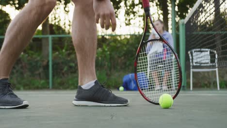 video of happy caucasian men picking up ball on the court