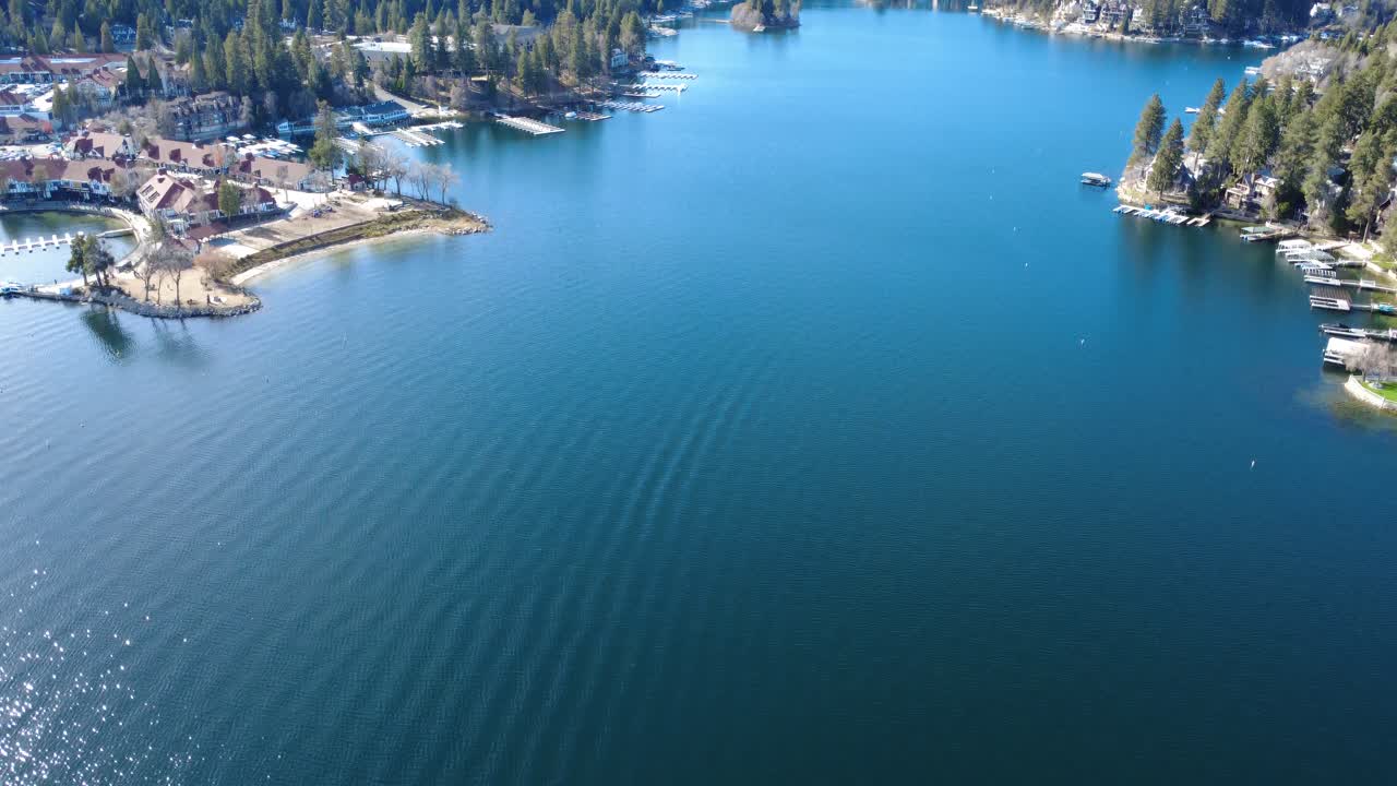 Lento movimento aereo del drone verso il cielo sopra le calme acque blu del lago artificiale Arrowhead nella California meridionale, una rinomata destinazione turistica montana