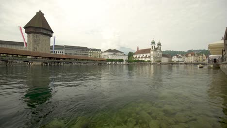 low angle shot of flowing river reuss, kapellbrücke in background